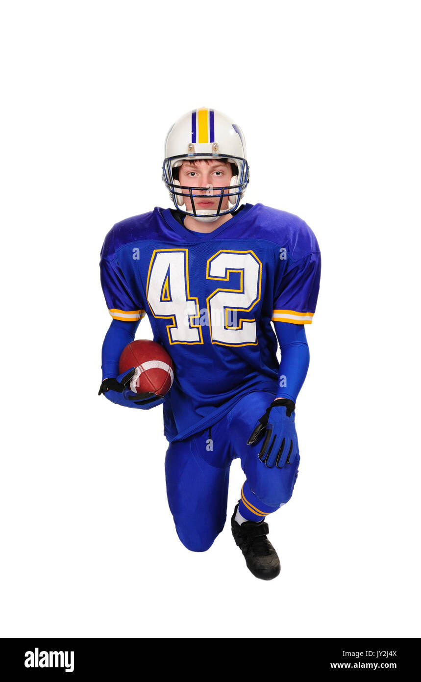 Teenage alta scuola calcio quarterback si inginocchia con tiro su sfondo bianco. Foto Stock