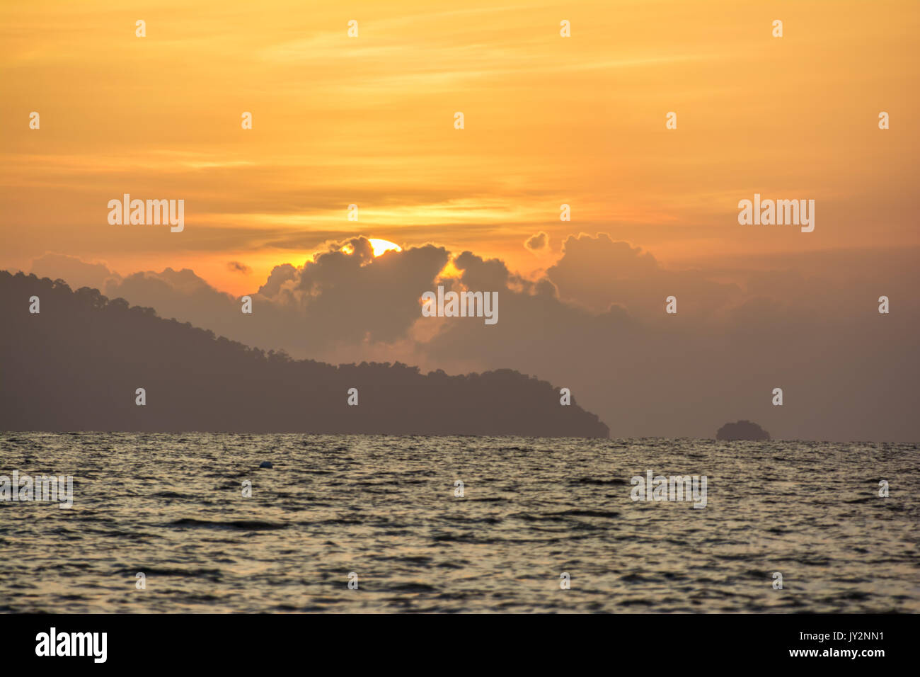 Arancione tramonto dietro la nuvola sul mare Foto Stock