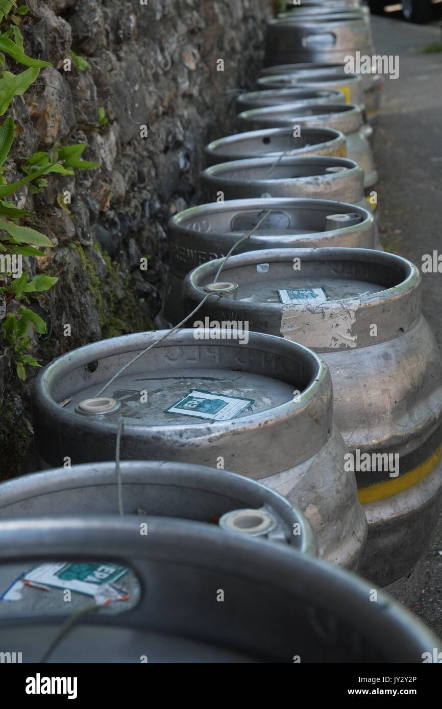 Barili di birra in una linea di raccolta attendono accanto a una parete al di fuori di un pub Foto Stock