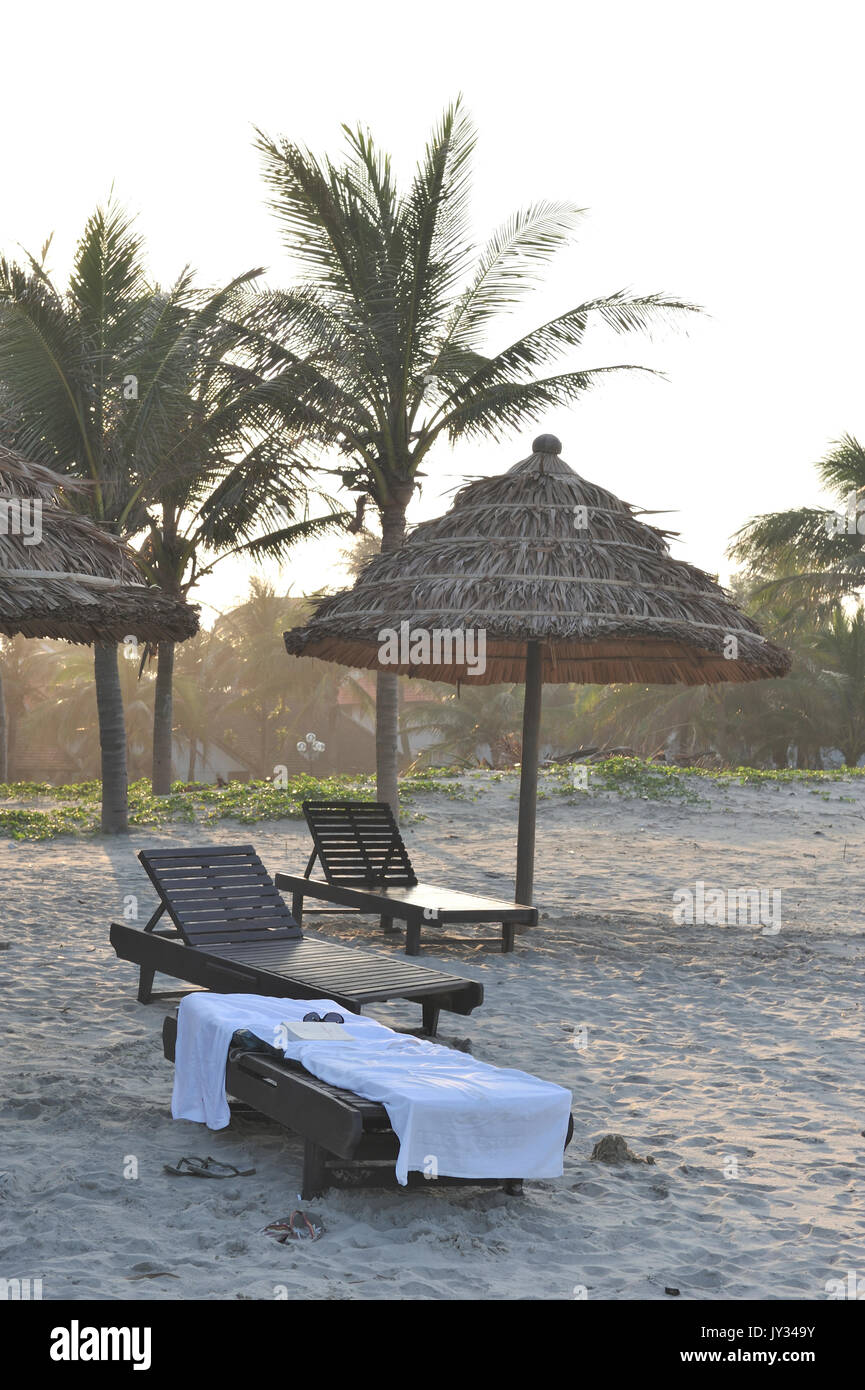 Sdraio da spiaggia spiaggia con coperchio in palm (Arecaceae) lascia a Hoi An Beach. Hoi An. Il Vietnam Foto Stock