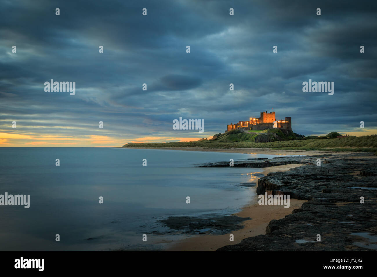 Il castello di bamburgh alba sul litorale di Northumberland Foto Stock