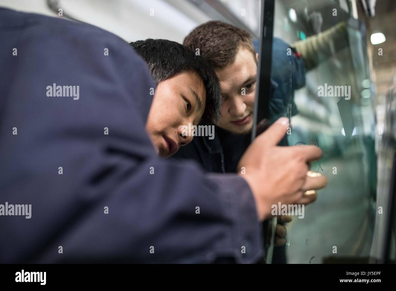 Di Kaluga, Russia. 18 Luglio, 2017. Russi e cinesi i lavoratori lavorano a un'automobile-galleggiante di livello linea di produzione di vetro piano in russo di fabbrica della Cina di vetro Fuyao Industry Group Co. di Kaluga, Russia, luglio 18, 2017. Gruppo Fuyao è un ben noto impresa cinese che è specializzata nella produzione di automobili di vetro di sicurezza e tecnologiche e industriali di vetro. Fuyao investito nel 2011 circa 200 milioni di dollari per la costruzione di automobili a livello di stabilimenti di produzione di vetro float in Kaluga. Credito: Wu Zhuang/Xinhua/Alamy Live News Foto Stock