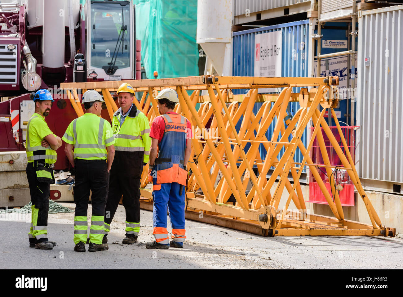 Kristiansand, Norvegia - 1 Agosto 2017: documentario della vita quotidiana nella città. Un gruppo di lavoratori edili avente la discussione. Parti di gru su polv Foto Stock