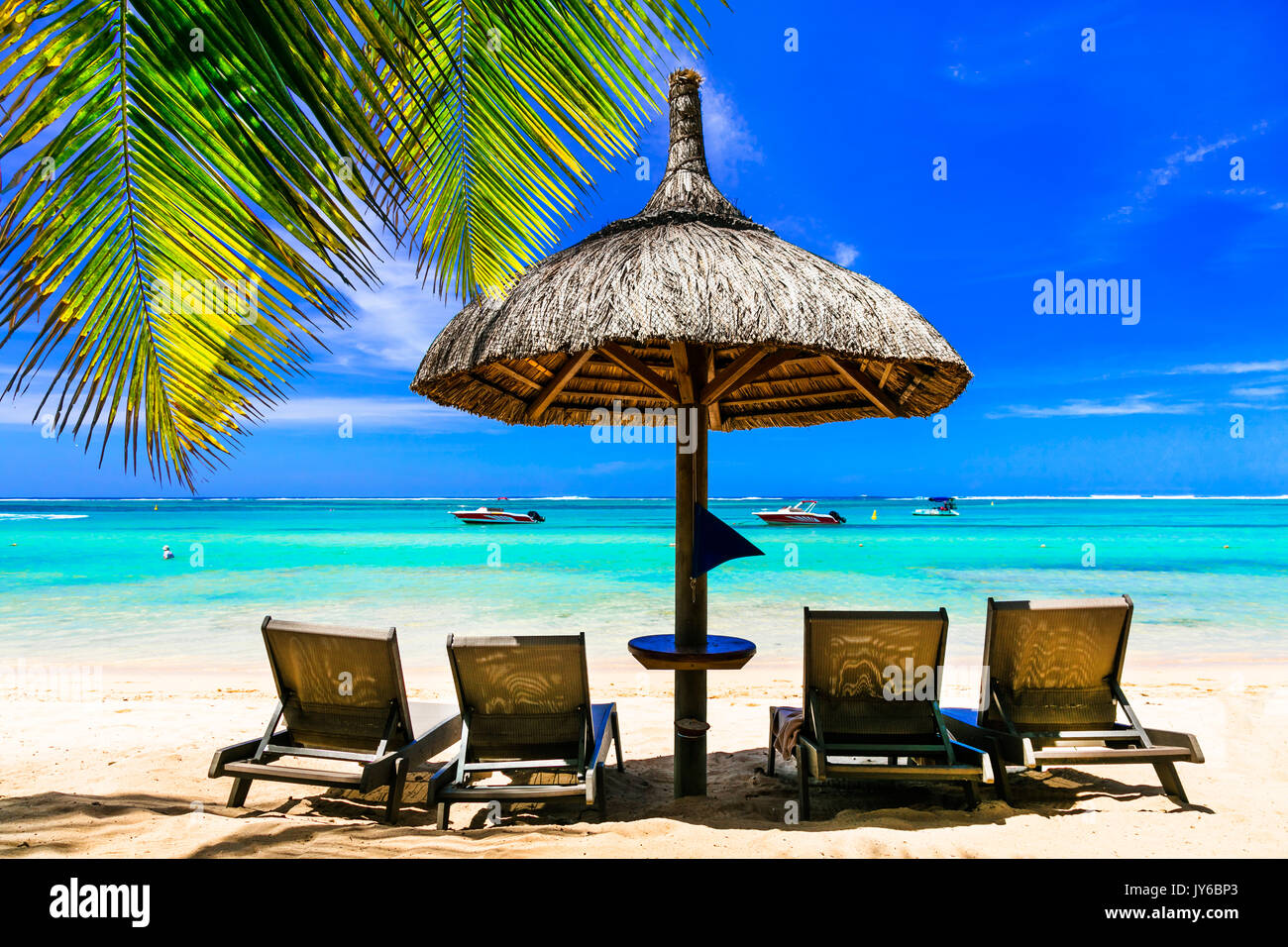 Rilassante scenario di spiaggia con ombrelloni e sedie a sdraio. Vacanze di lusso in isola Maurizio Foto Stock