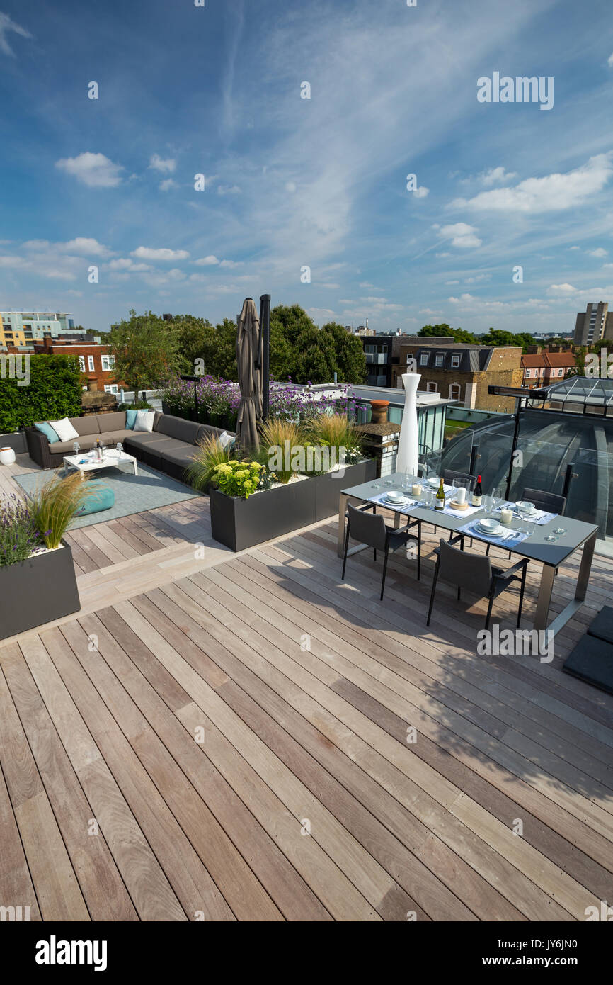 Lussuosa terrazza sul tetto a Londra con legno duro decking, piantatrici contemporanea con lussureggiante piantagione e moderni arredi per esterni Foto Stock