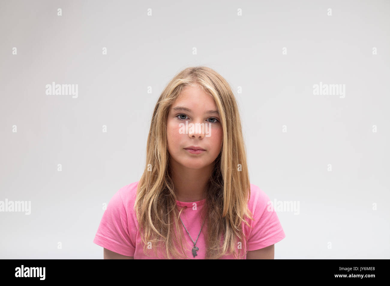 Ritratto di una poppa molto gravi e poco adorabile ragazza su una t-shirt rosa su sfondo bianco Foto Stock