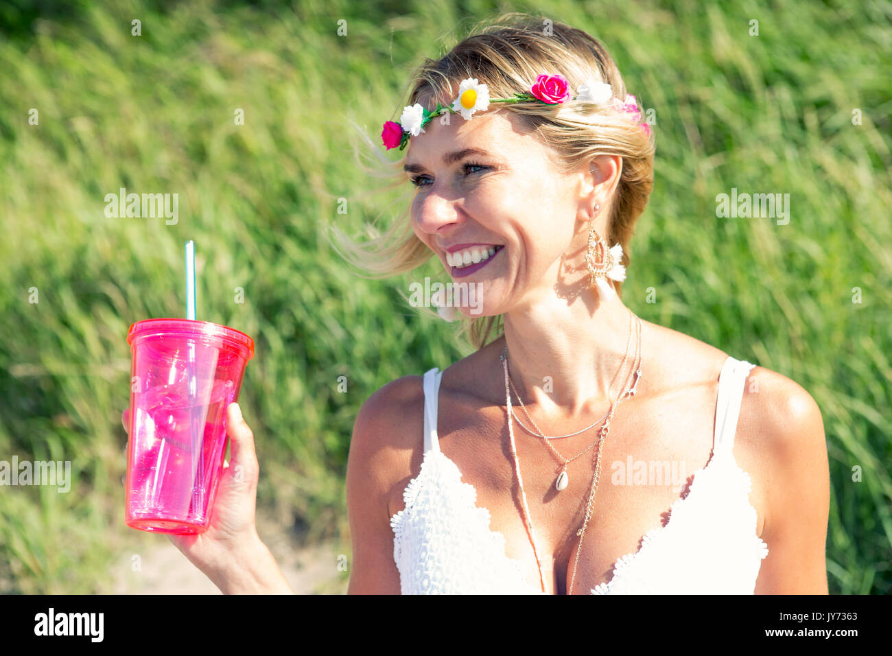Ritratto di donna bionda con fiori nei capelli e tenendo una tazza Foto Stock