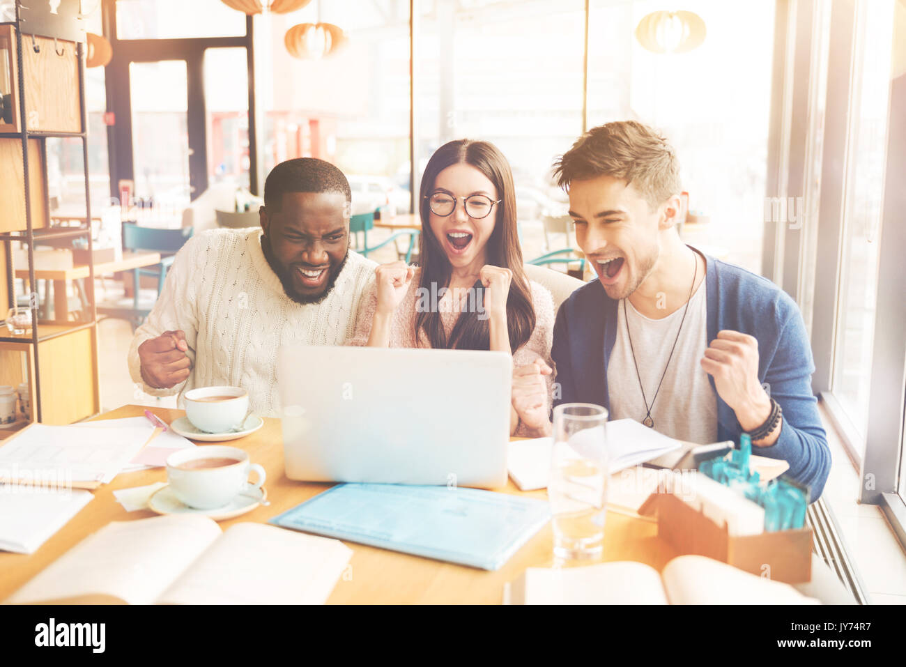 Overjoyed gli studenti internazionali in seduta il cafe Foto Stock