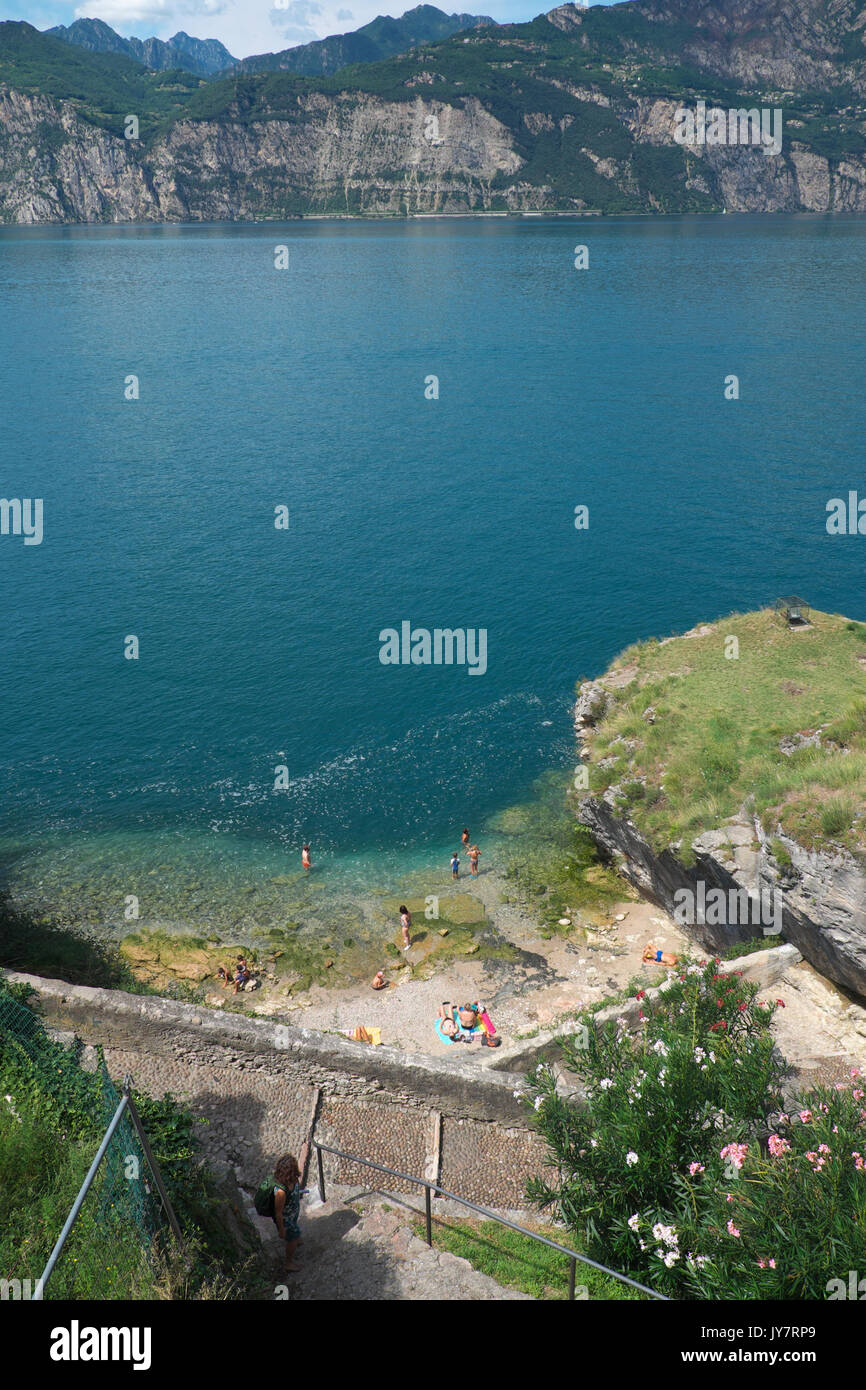 Malcesine, Lago di Garda, Italia - i turisti nuotare nel lago di Garda ad una piccola spiaggia di Malcesine Foto Stock