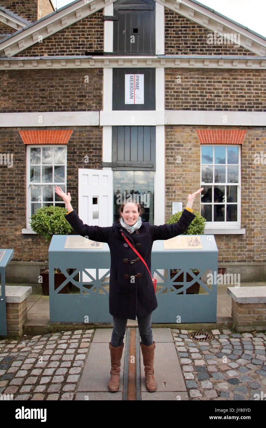Una donna scavalca il meridiano di Greenwich Foto Stock