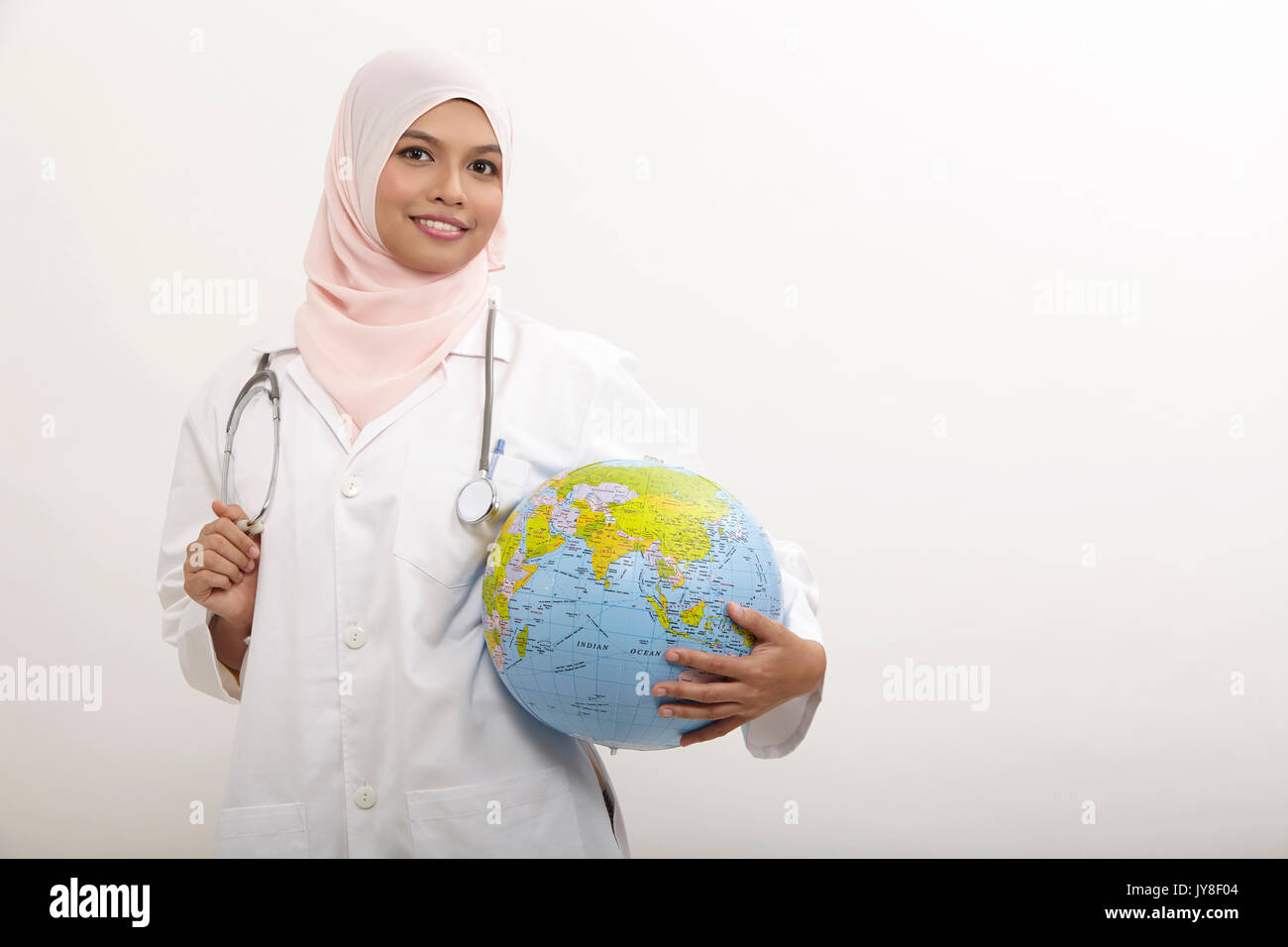 Il malese medico donna holding globe sullo sfondo bianco Foto Stock