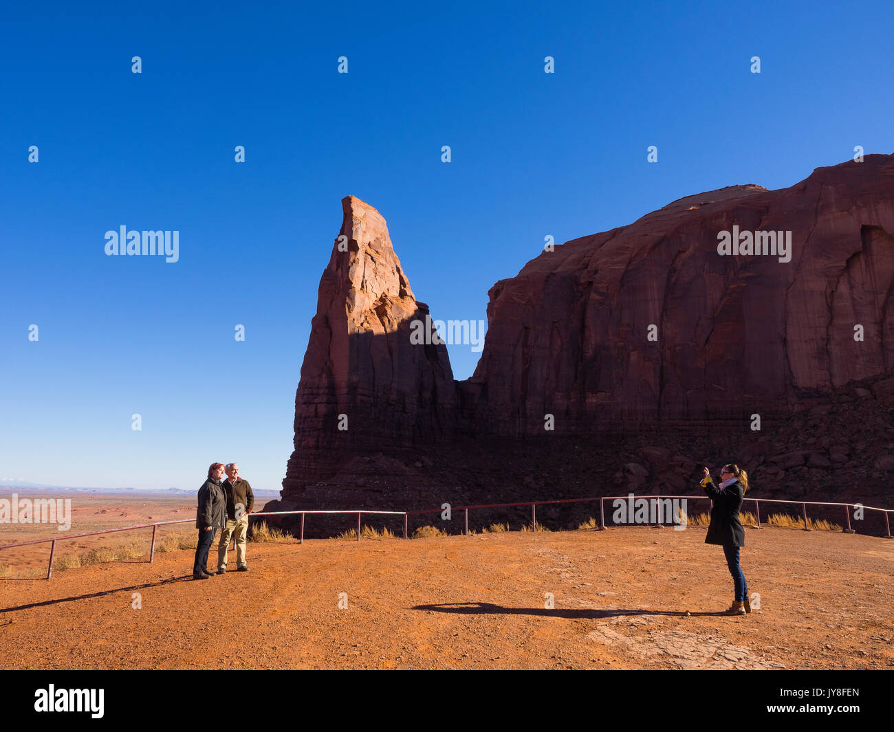 Il Monument Valley, Utah, Stati Uniti d'America. Un turista scatta una fotografia di una coppia in visita presso un Monument Valley viewpoint. Foto Stock