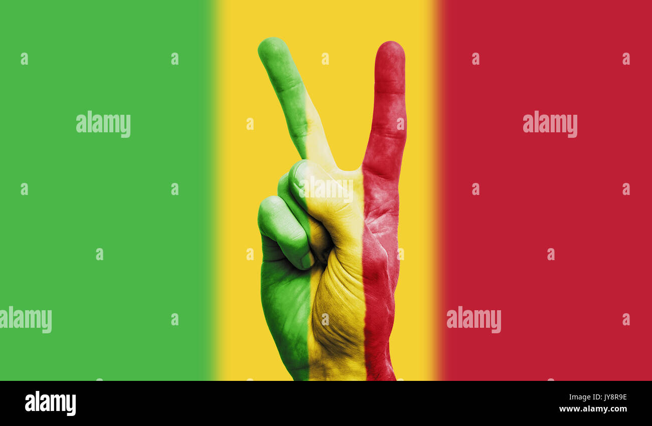 Mali bandiera nazionale verniciato su un lato maschio che mostra una vittoria, pace, forza di segno Foto Stock