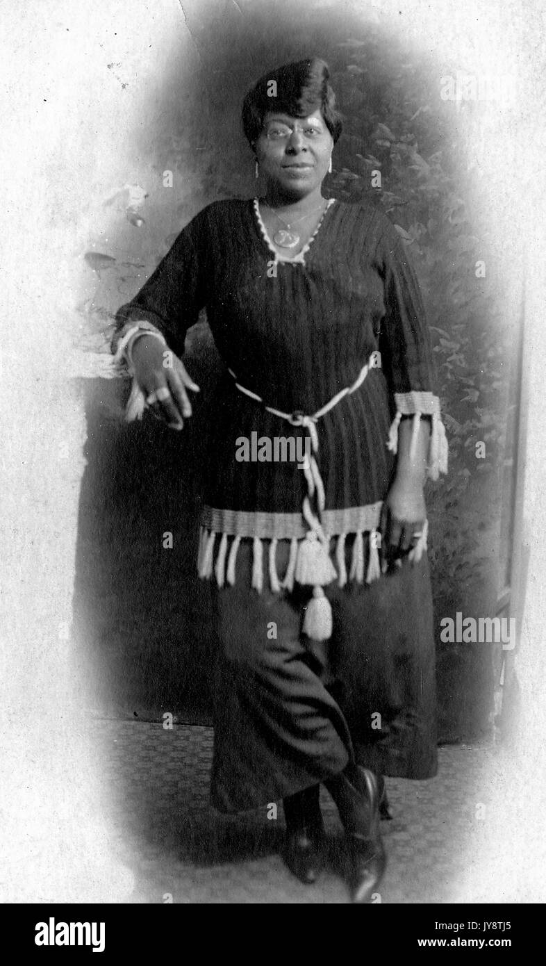 A piena lunghezza Ritratto di African American donna che indossa camicia e pantaloni con elaborati corda frange, 1944. Foto Stock