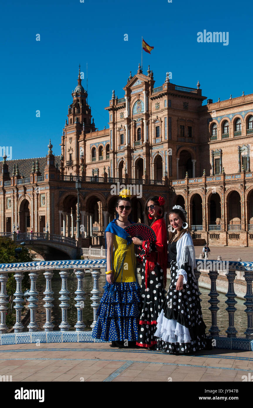 Spagna: le ragazze di Siviglia in abiti tipici in Plaza de Espana, la piazza più famosa della città, pronti per la fiera di Siviglia (Feria de abril) Foto Stock