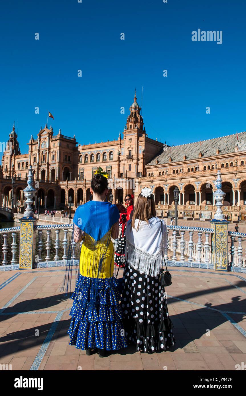 Spagna: le ragazze di Siviglia in abiti tipici in Plaza de Espana, la piazza più famosa della città, pronti per la fiera di Siviglia (Feria de abril) Foto Stock