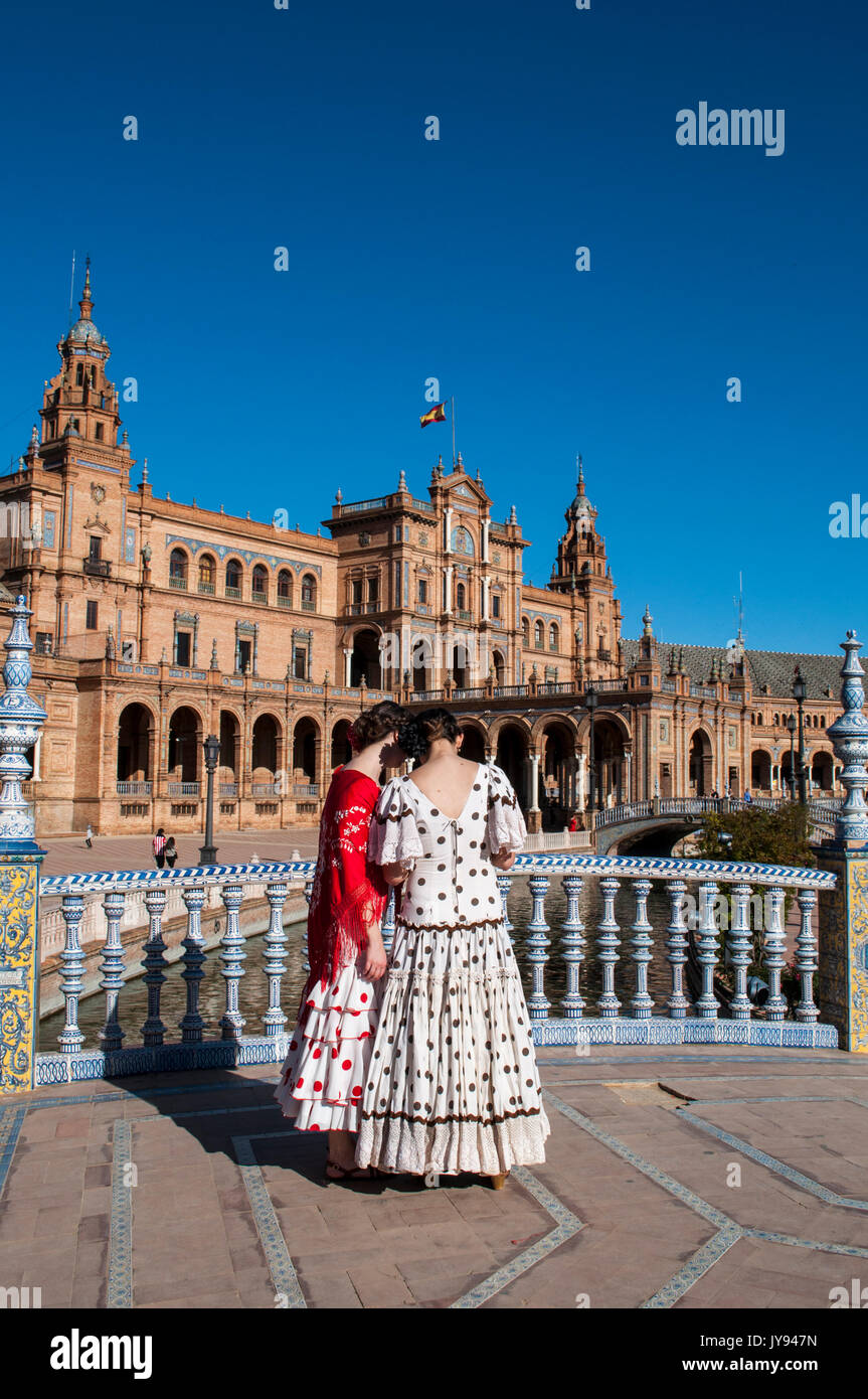 Spagna: le ragazze di Siviglia in abiti tipici in Plaza de Espana, la piazza più famosa della città, pronti per la fiera di Siviglia (Feria de abril) Foto Stock