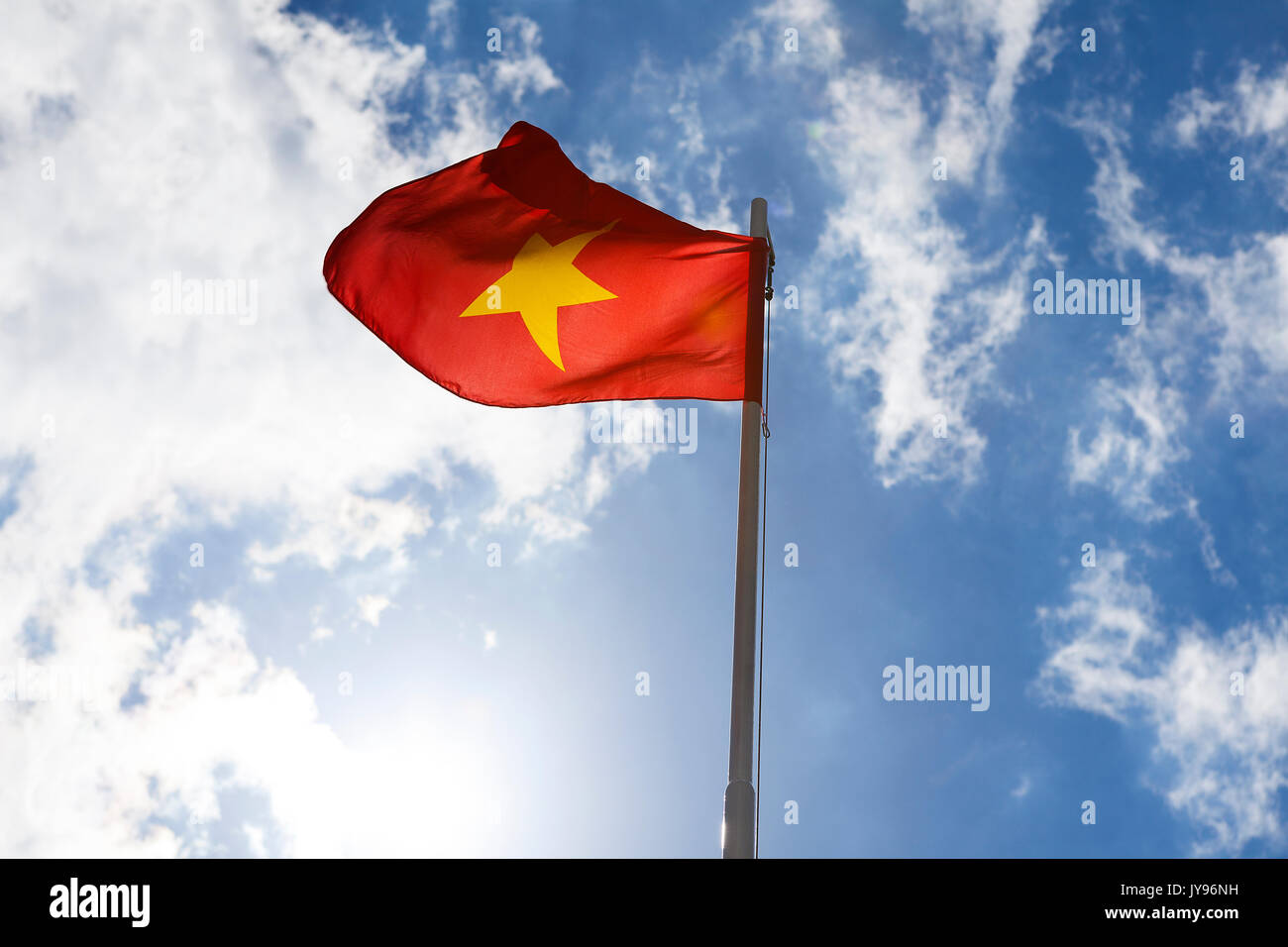 Bandiera nazionale del Vietnam su un pennone di fronte blu cielo Foto Stock