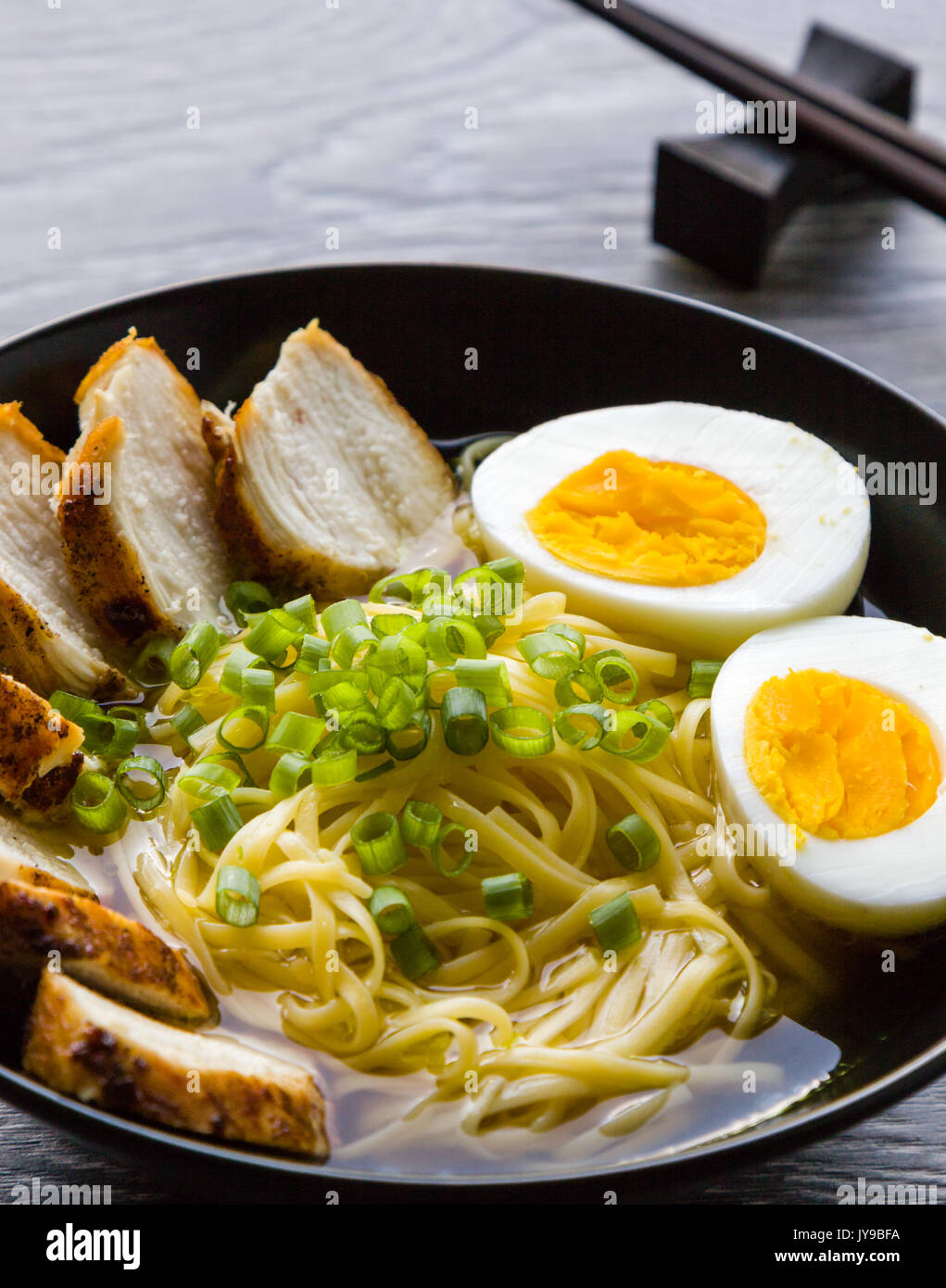 Giapponese ramen zuppa di pollo e uova sode o nel vaso nero Foto Stock