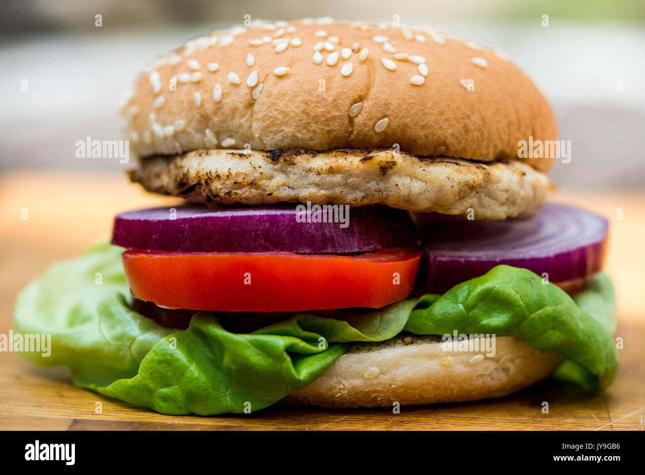 Hamburger di pollo o sandwich in un pane di sesamo rotolo con insalata fresca Foto Stock