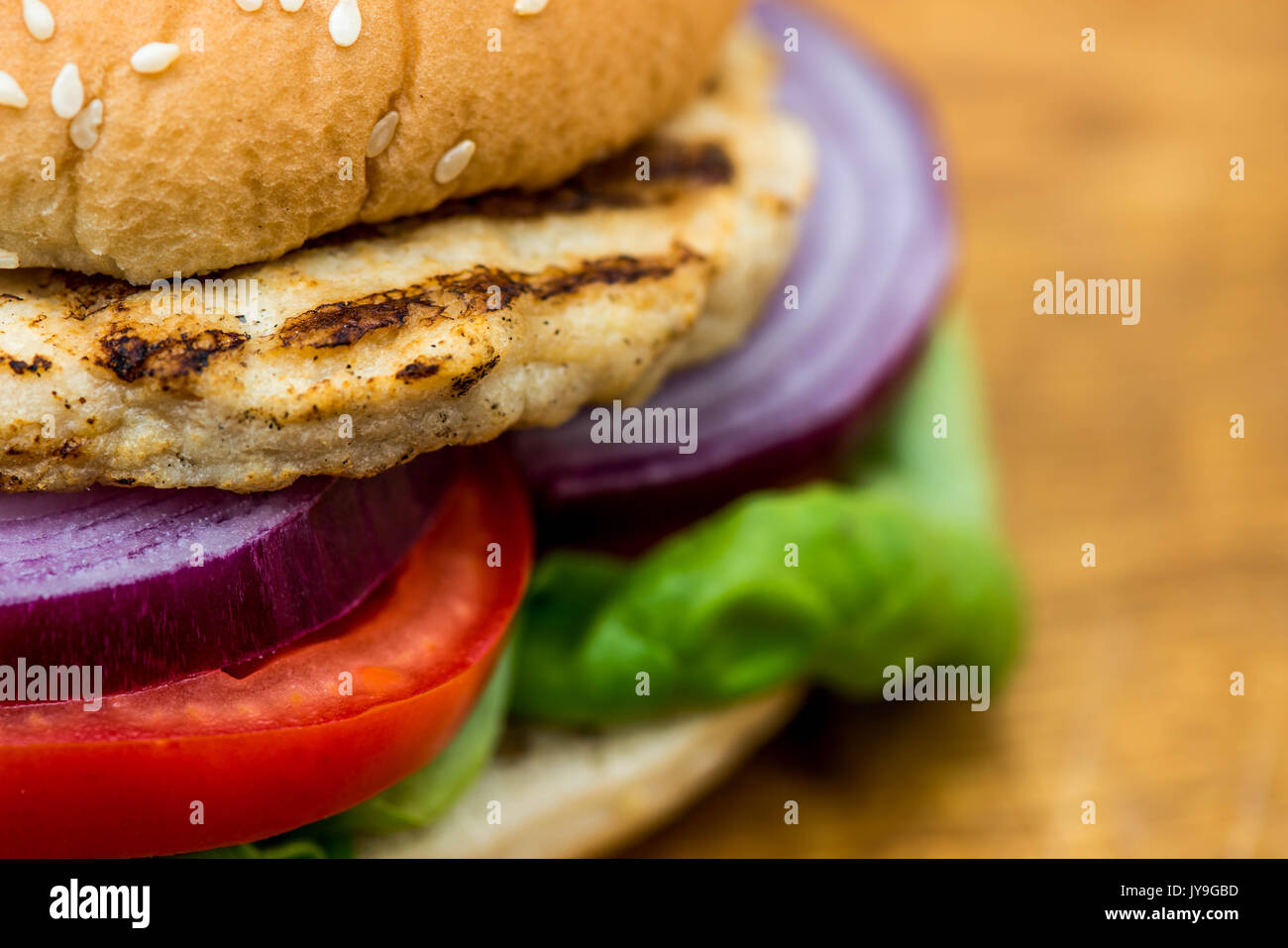 Hamburger di pollo o sandwich in un pane di sesamo rotolo con insalata fresca Foto Stock