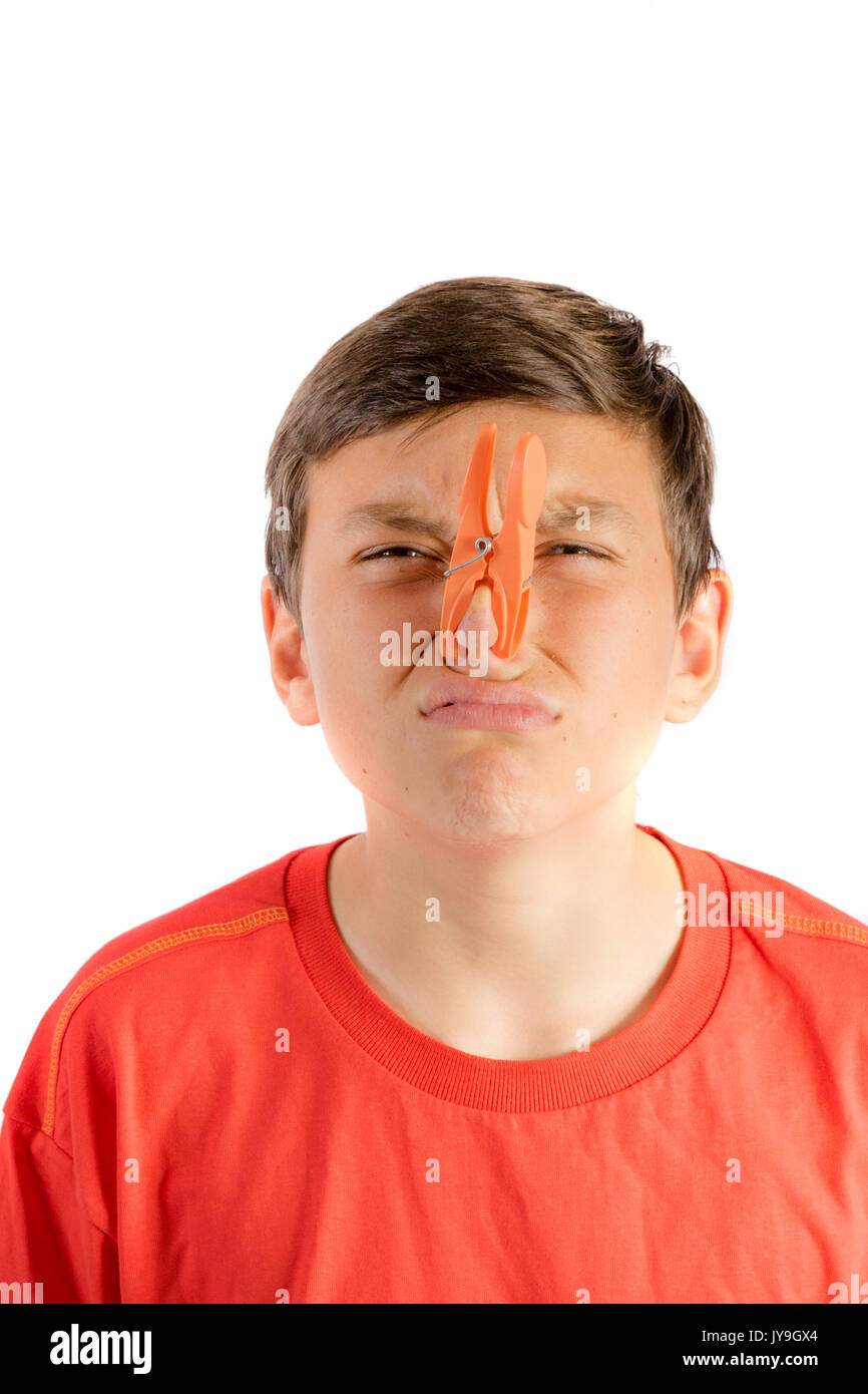 Giovane ragazzo adolescente isolato su uno sfondo bianco con una molletta  da bucato sul suo naso Foto stock - Alamy