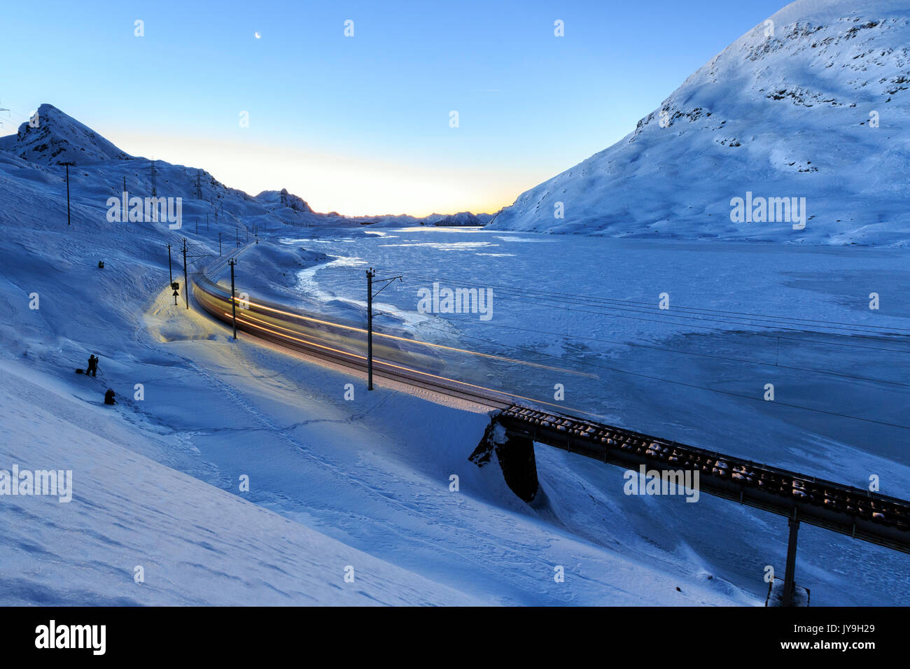 Il Bernina Express Patrimonio Unesco passa al passo del Bernina al crepuscolo. Il Cantone dei Grigioni. Engadina. La Svizzera. Europa Foto Stock