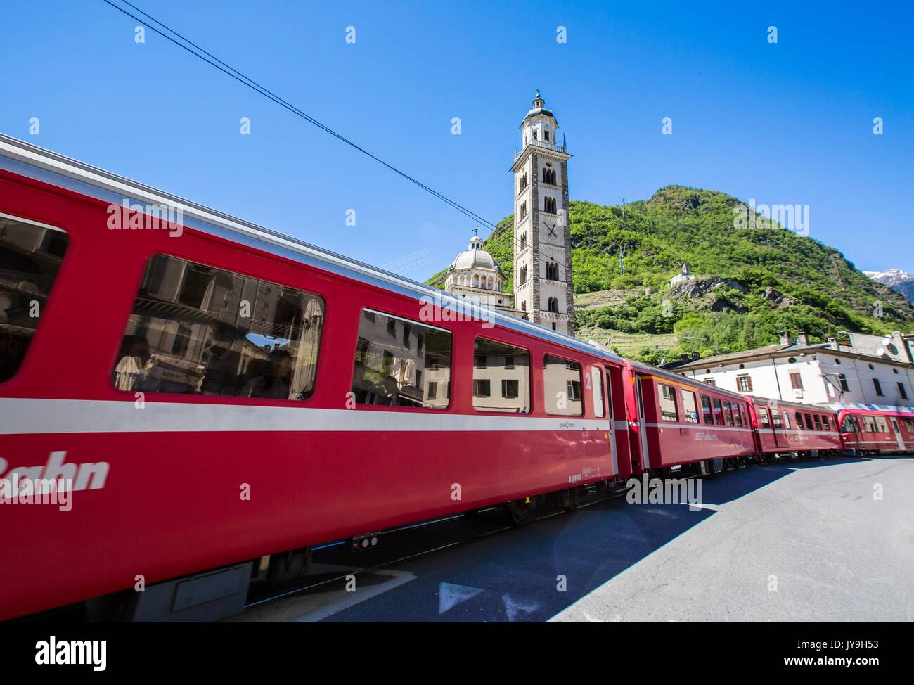 Il Trenino Rosso passa a Tirano, il punto di partenza della Ferrovia Retica. Quindi il tradizionale rosso carrelli trasgressione in Svizzera portando turi Foto Stock