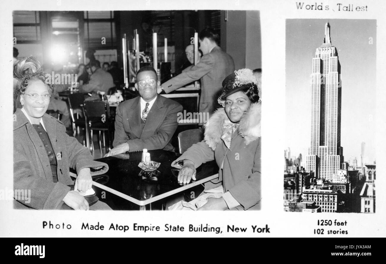 L'uomo afroamericano e due donne in una fotografia scattata in cima all'Empire state Building, un souvenir turistico che mostra l'uomo e le donne seduti a un tavolo in un bar, con un'immagine dell'Empire state Building e un sottotitolo che legge i mondi più alti, New York City, New York, 1932. Foto Stock