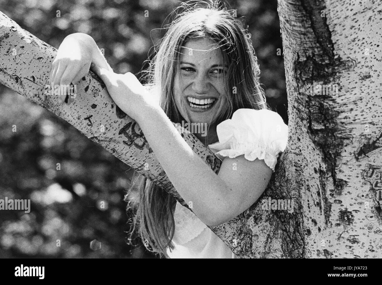 Una fotografia di una femmina di studente universitario presso la Johns Hopkins University di ridere e di posa con un albero sul campus durante i primi anni del corso di laurea di primo livello di ammettenza di donne, a Baltimora, Maryland. 1970. Foto Stock