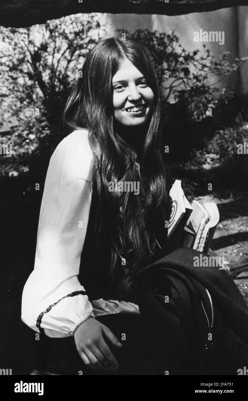 Una fotografia ritratto di una studentessa sorridente laureata alla Johns Hopkins University, seduta fuori dal campus durante i primi anni di ammissione delle donne nel programma di laurea, a Baltimora, Maryland. 1970. Foto Stock