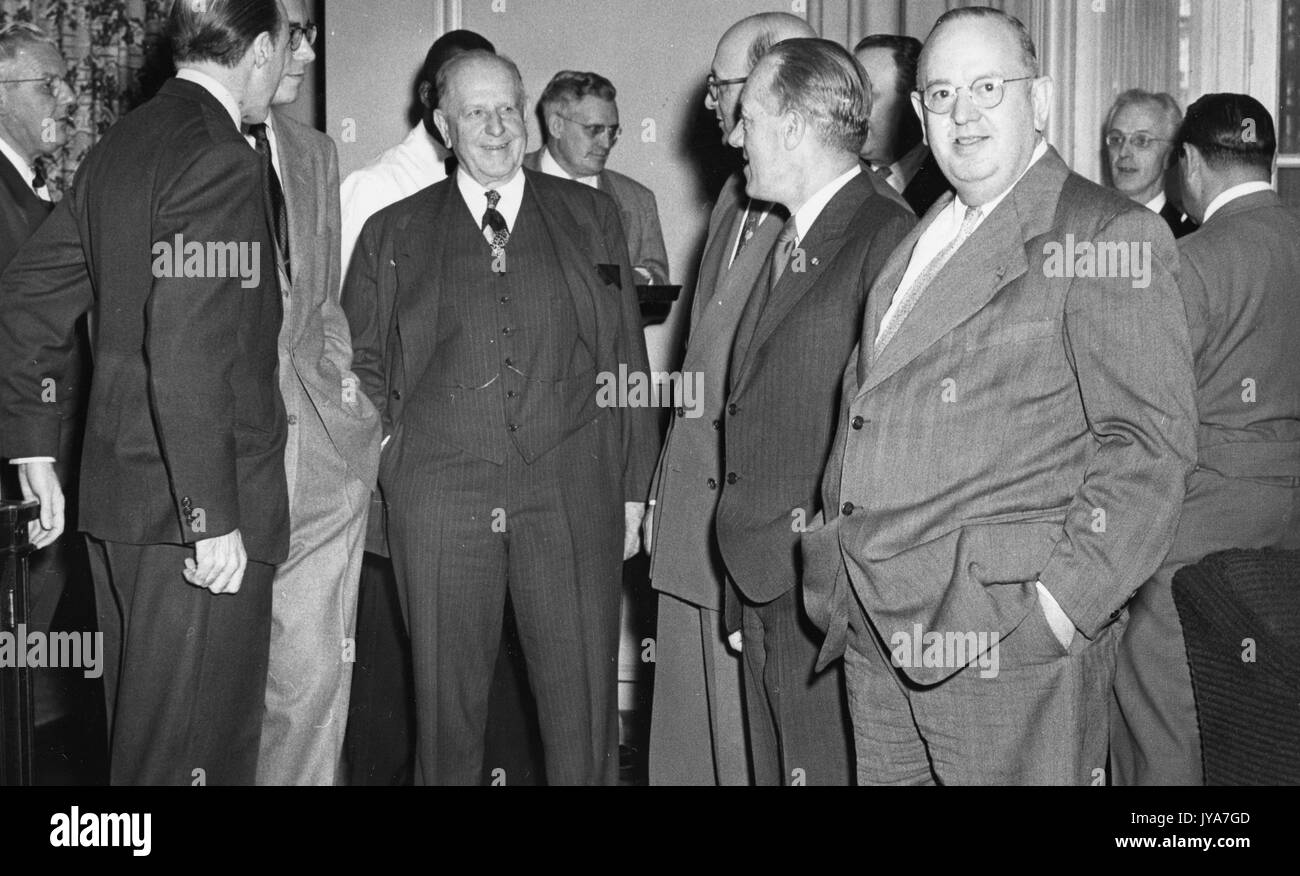 Foto di un gruppo di ben vestito uomini, comprese American educatore detlev bronk, piedi intorno il senatore George radcliffe, non ci sono più gli uomini dietro il senatore, maggio 1951. Foto Stock