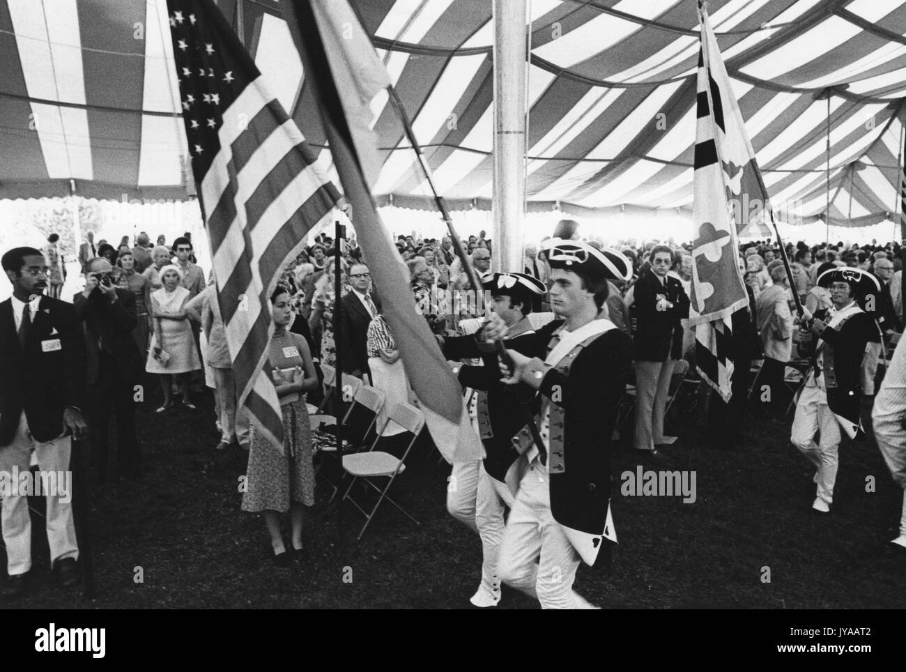 Bandiere e pubblico sotto una tenda alla cerimonia di apertura della Convocazione Bicentennial tenutasi al campus Homewood della Johns Hopkins University, 16 luglio 1976. Foto Stock