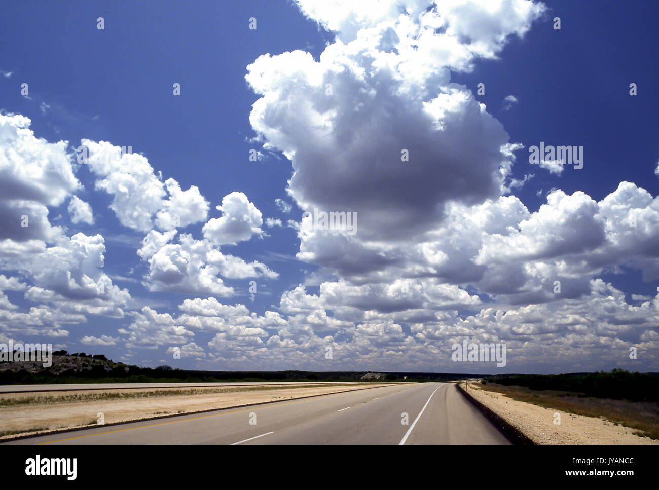 Nuvole blu cielo cielo e terra Ampia angolazione del brillante cumulous celesti nuvole che pende sulla autostrada vuota all orizzonte strada aperta Myrleen Pearson Foto stock Alamy