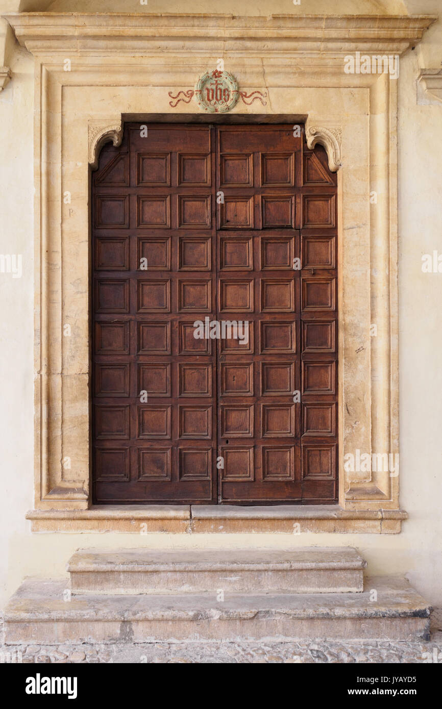 Decorate vecchia porta di legno di un italiano di chiesa medievale di Spello. Formato verticale. Foto Stock