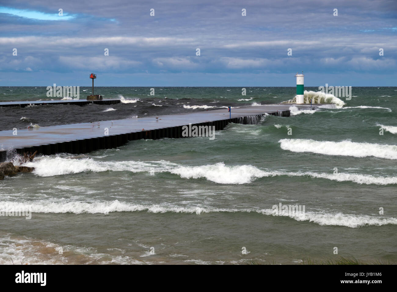 Piersr e luci di navigazione presso il Lago Bianco canale prendendo un martellamento da 6 e 7 piedi onde in rotolamento dal Lago Michigan. Foto Stock