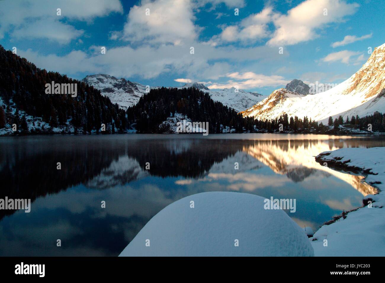 Le vette illuminate dal Risorto recentemente sun sono riflesse nel lago Cavloc a Maloja Pass. Engadina. La Svizzera. Europa Foto Stock