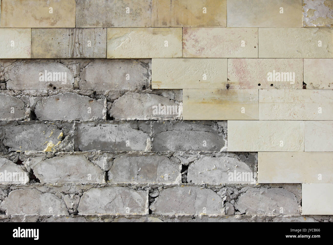 Grande Muro beige piastrelle è caduto, la consistenza del calcestruzzo di fondazione. Di lavoro difettoso. Foto Stock