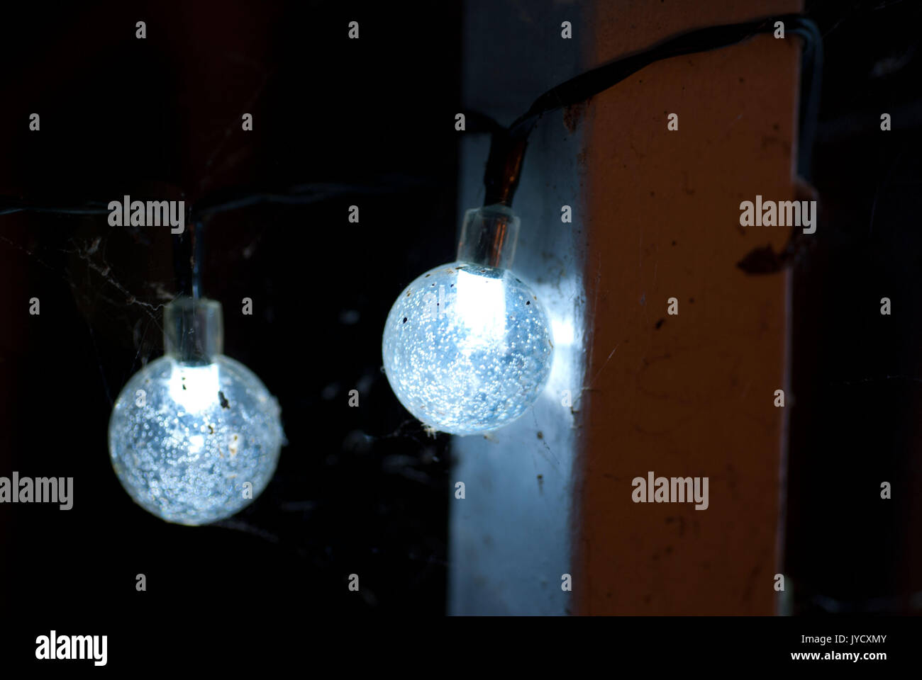 Riprese macro di spiderwebs costruita sulla sfera bluastra luci di stringa Foto Stock