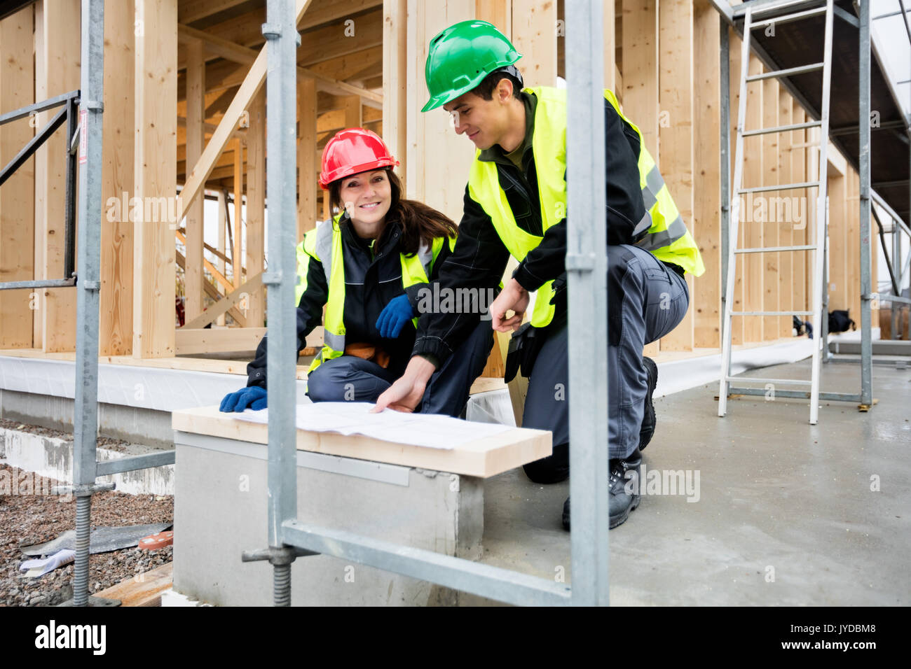 Architetto femmina sorridere mentre seduta dal collega al sito Foto Stock