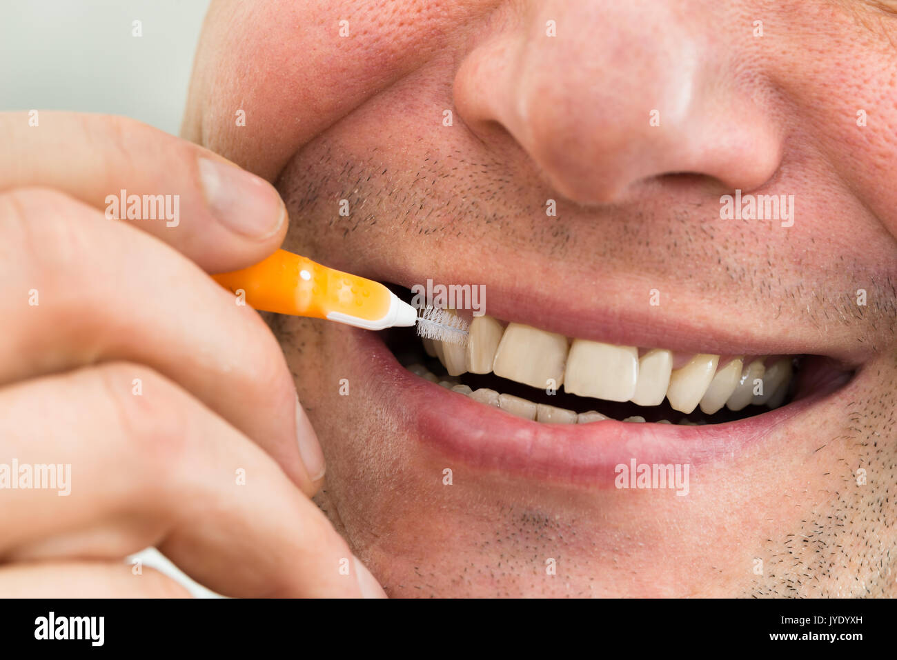 Donna di pulizia dei denti di lei con uno scovolino interdentale Foto stock  - Alamy