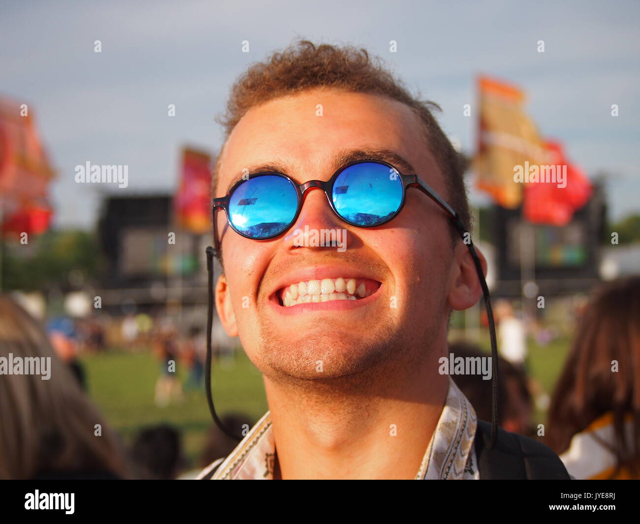 UK - 22 Giugno, 2017: Un uomo sorridente e felice in un festival musicale che indossa occhiali da sole Foto Stock