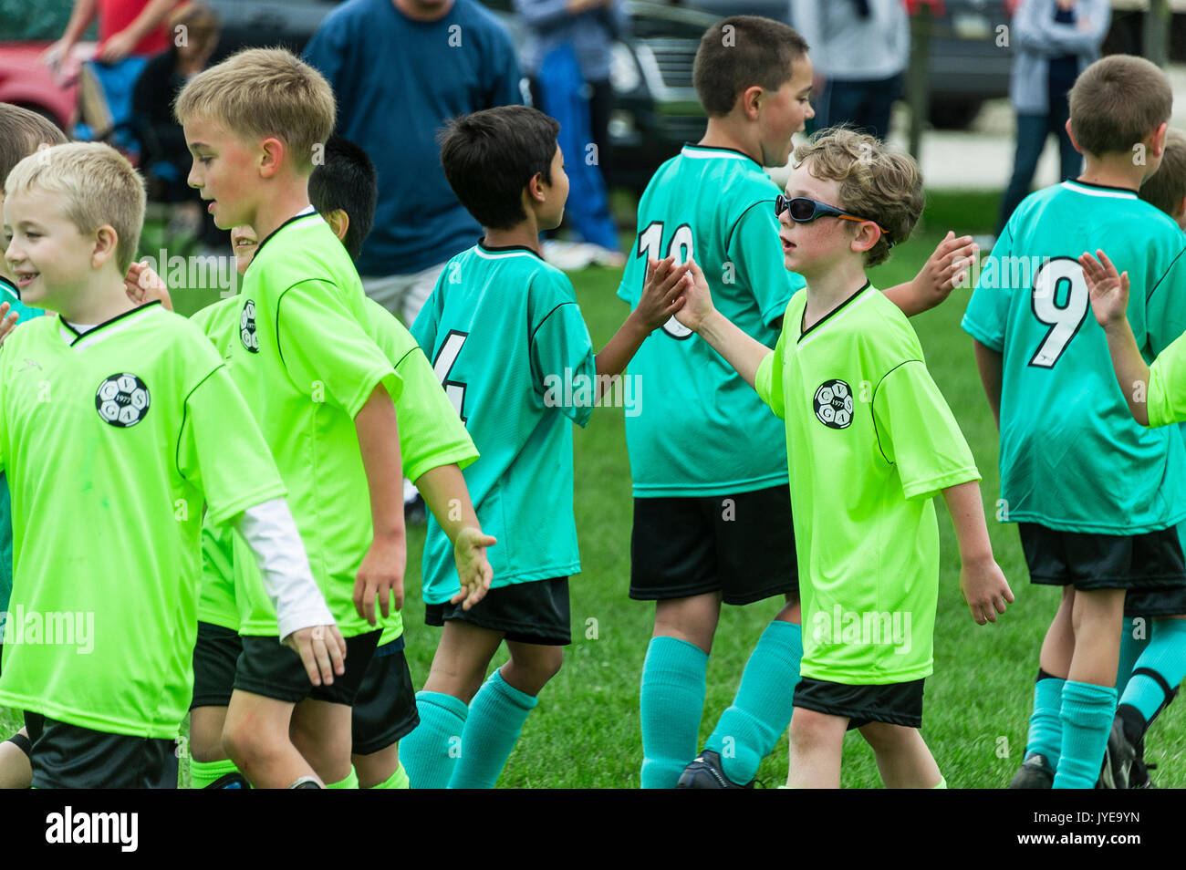 Giovani ragazzi squadre di calcio di agitare le mani dopo una partita. Foto Stock