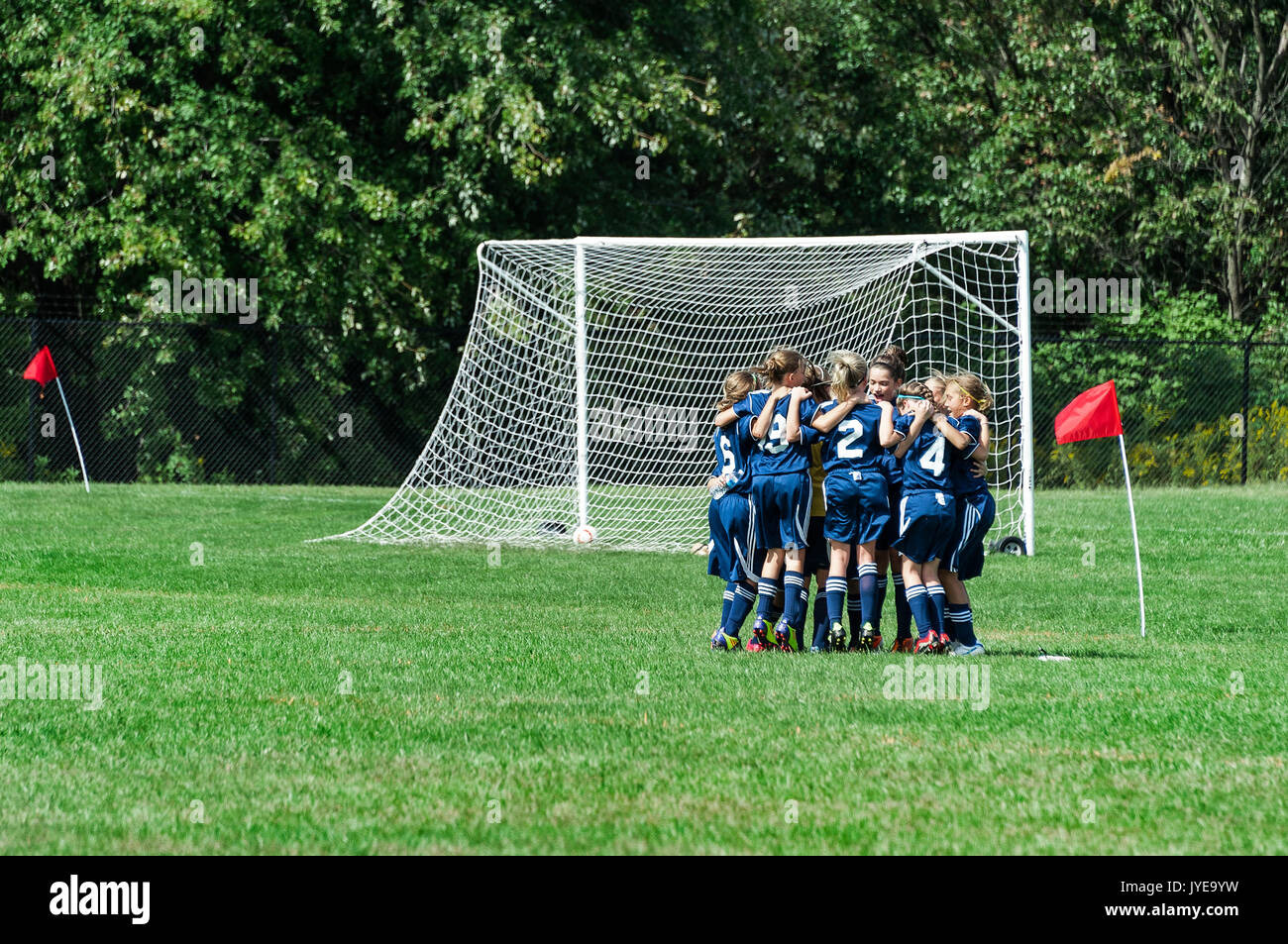 Le ragazze della gioventù Calcio team huddles prima partita. Foto Stock