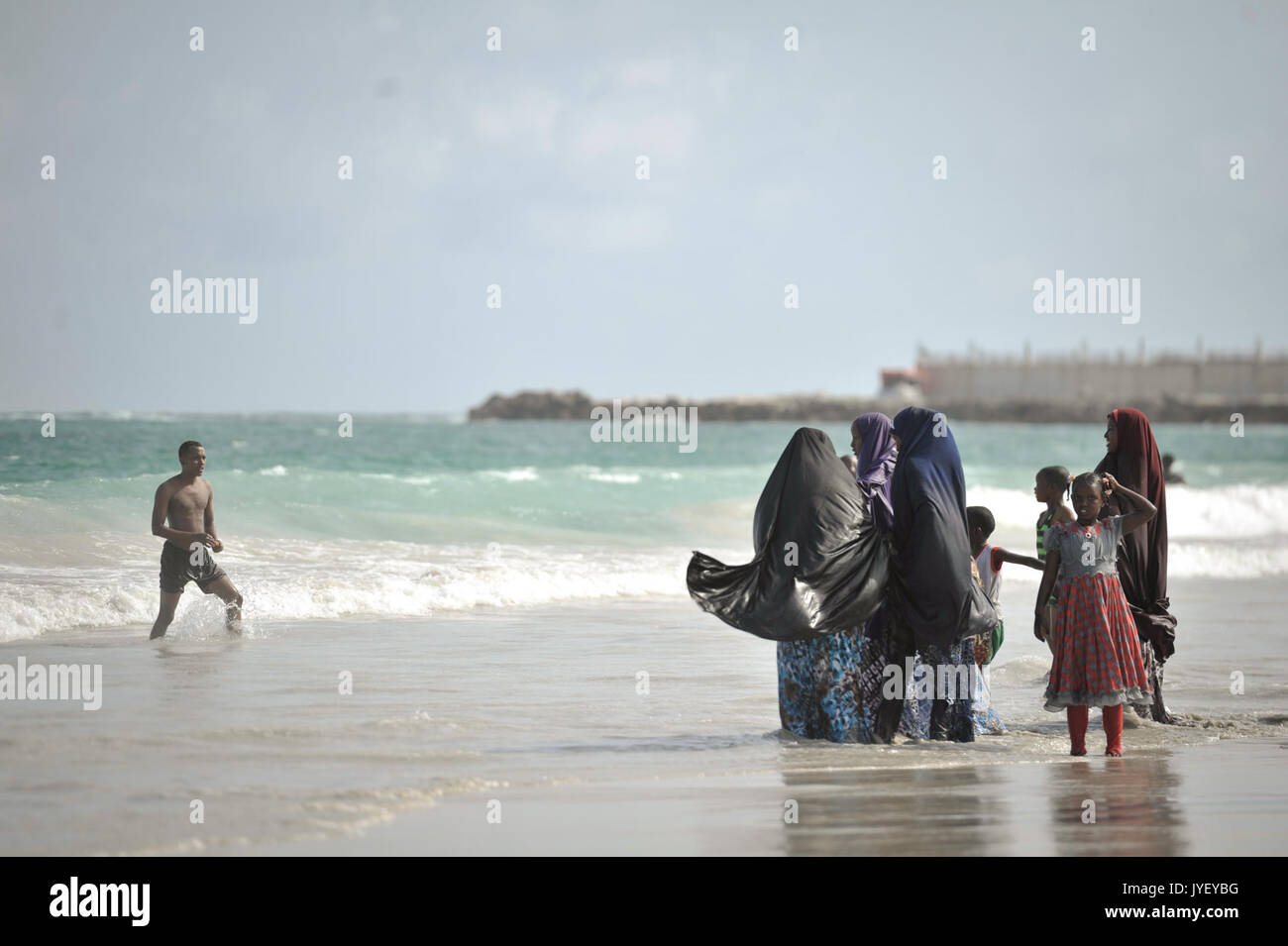 Una famiglia sta nell'oceano sulla Spiaggia del Lido a Mogadiscio, Somalia, durante l'Eid Al Fitr il 28 luglio. AMISOM Foto Tobin Jones (14765518864) Foto Stock