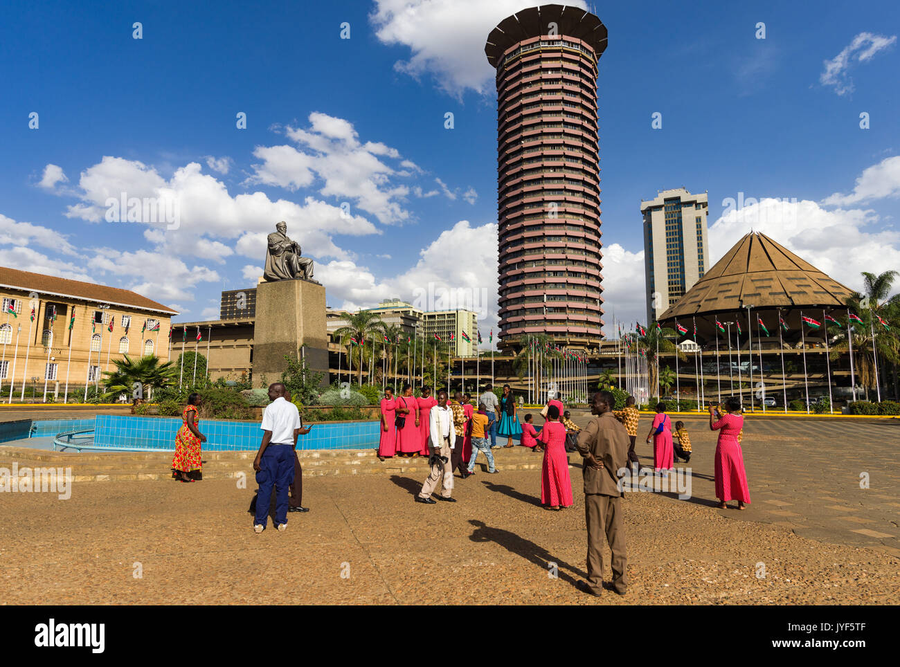 Persone in piedi da Jomo Kenyatta statua con Kenyatta International Convention Center in background, Nairobi, Kenia Foto Stock