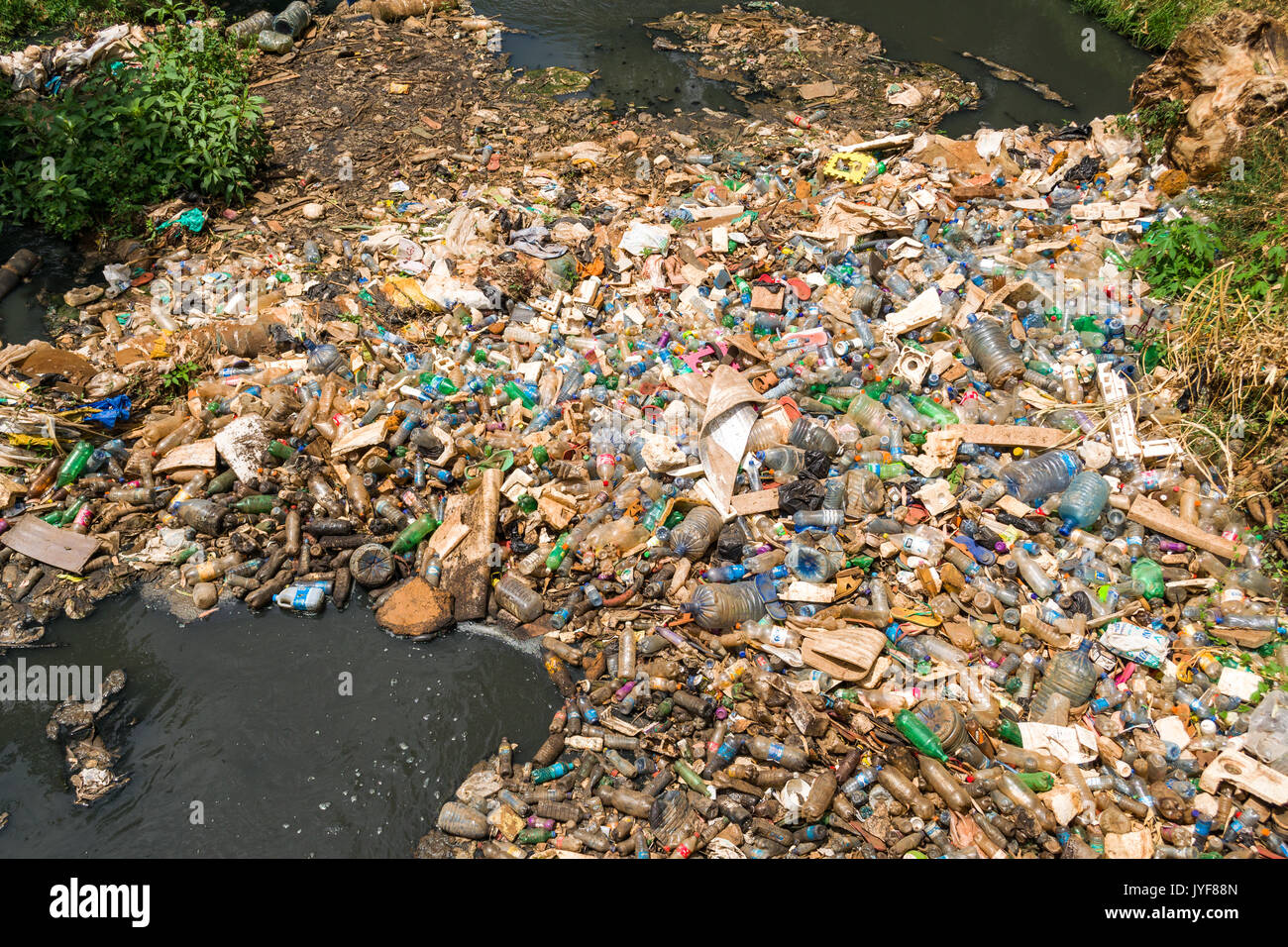 Bottiglie di plastica e altri rifiuti spazzatura bloccando il fiume di Nairobi, Kenya Foto Stock