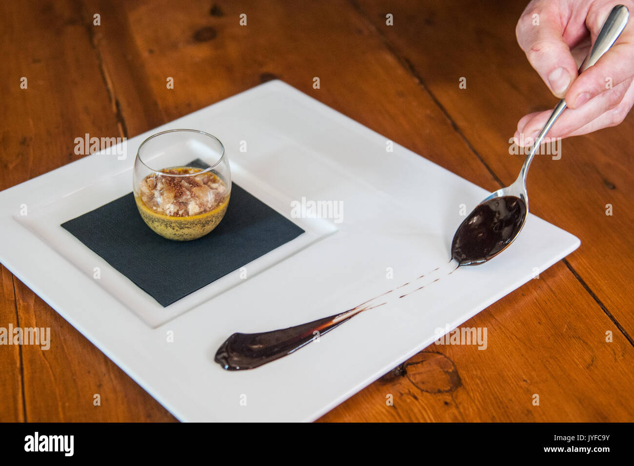 Uno chef decorare un piatto con il cioccolato Foto Stock