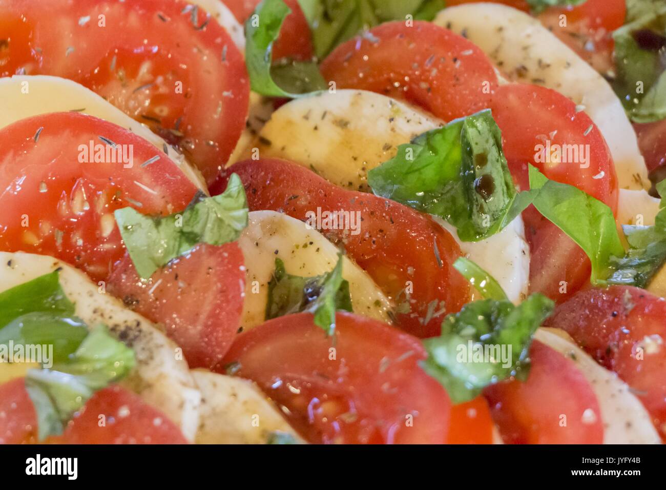 Deliziosi pomodori e mozzarella tritati in insalata di primo fila. Ottimo antipasto vegetariano vegano. Verde, bio e cibo locale. Formaggio di pomodoro in file Foto Stock