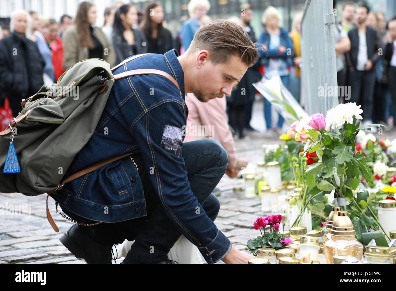 Turku, Finlandia. 19 Ago, 2017. Un uomo mette una candela per commemorare le vittime del venerdì di stabbings lo a Turku Piazza del Mercato, Finlandia del 19 agosto, 2017. Un altro quattro marocchini sono stati arrestati e un mandato è stato emesso per un quinto dopo un giovane uomo pugnalato persone presso le piazze nel sud-ovest della città finlandese di Turku, la polizia ha detto che il sabato. (Xinhua/Zhang Xuan) (zjl) Credito: Xinhua/Alamy Live News Foto Stock